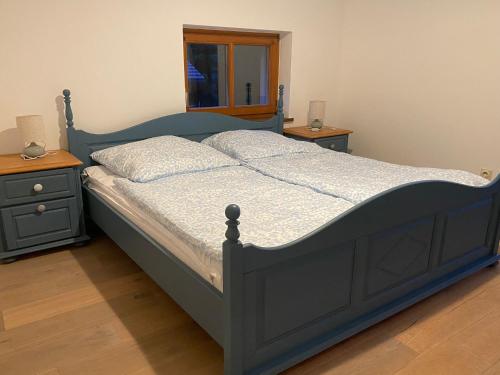 a bedroom with a blue bed with two night stands at Ferienwohnung Lentner in Büchlberg