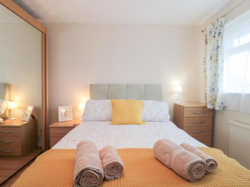 a bedroom with a bed with towels on it at Jay Cottage in Weymouth