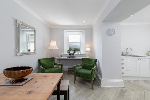a living room with two green chairs and a table at Stunning 2 bedroom Apartment in Central Keswick in Keswick