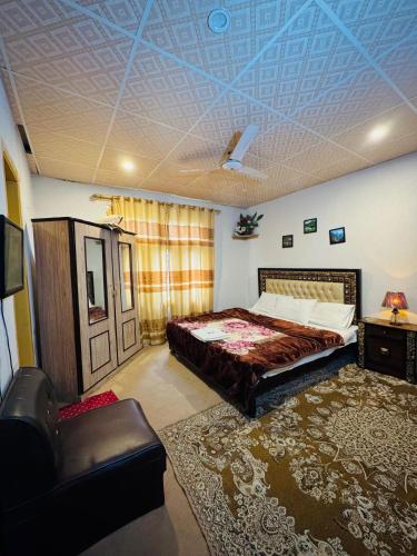 a bedroom with a bed and a couch in it at Skardu Baltistan Village Guest House in Skardu