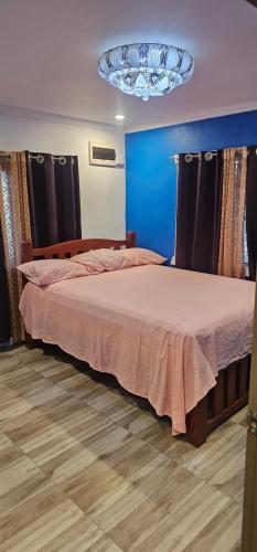 a bedroom with two beds and a chandelier at Racecourse Apartment in Mba