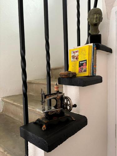 un livre et une machine à coudre sur une étagère dans l'établissement Domaine du Loup, à Four