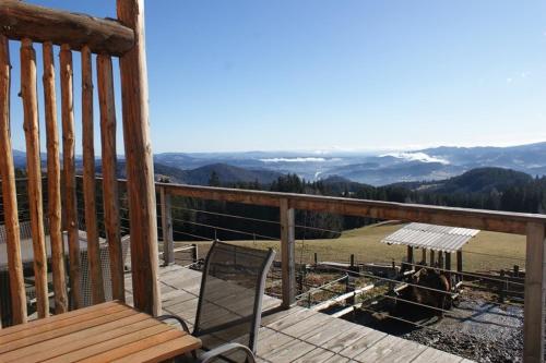 una terraza de madera con un banco y vistas a la montaña en Trakehnerstüberl, 