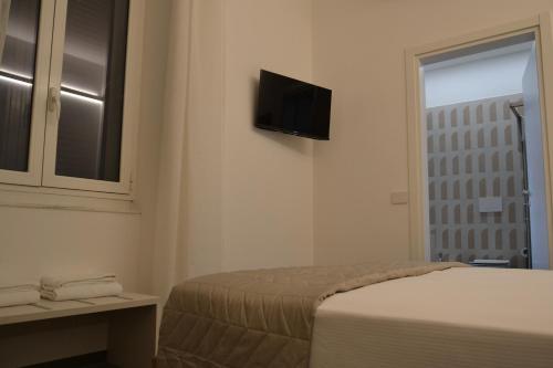 a bedroom with a bed and a television on the wall at Le camere in città in La Spezia
