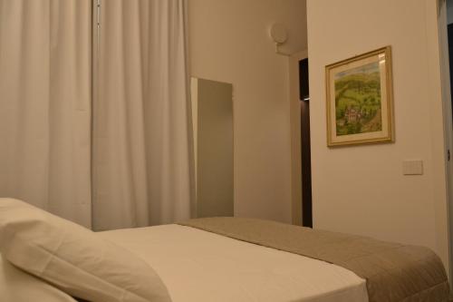 a bedroom with a bed and a window with a picture at Le camere in città in La Spezia