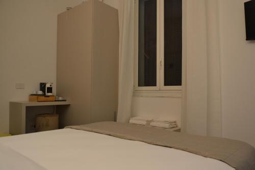 a bedroom with a white bed and a window at Le camere in città in La Spezia