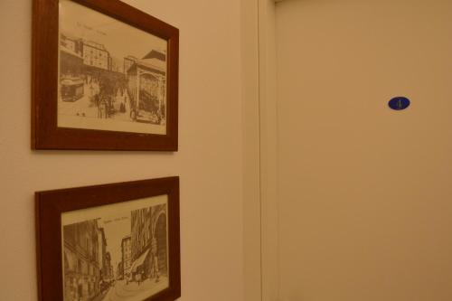 two pictures hanging on a wall next to a door at Le camere in città in La Spezia