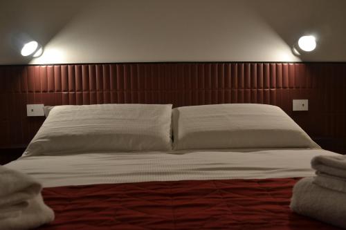 a bedroom with a large bed with a wooden headboard at Le camere in città in La Spezia