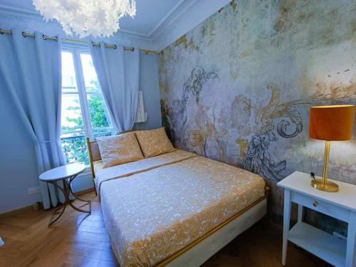 1 dormitorio con 1 cama y un mural en la pared en Au Petit Trianon Bleu, en Versalles