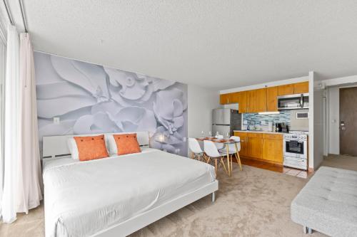 a bedroom with a white bed and a kitchen at Marine Surf 18FL Newly Renovated - Free Parking in Honolulu