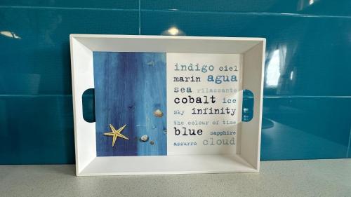 a framed picture of a blue door with a sign at Casa Arena y Mar in Telde