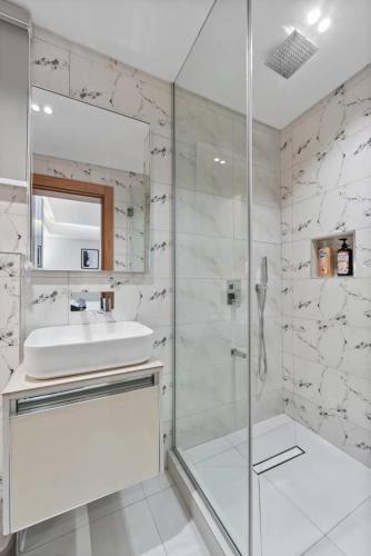 a white bathroom with a sink and a shower at Luxury 2 Bed in Lagos