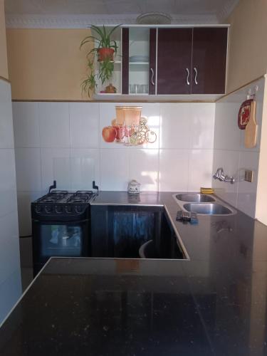 a kitchen with a stove and a sink at Hostal Cadena in Tupiza