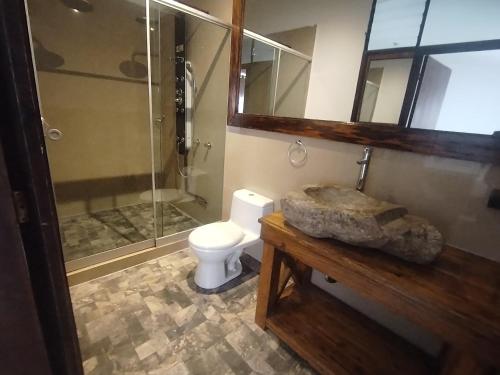 a bathroom with a toilet and a glass shower at Casa Cavassa Centro Histórico Cusco in Cusco