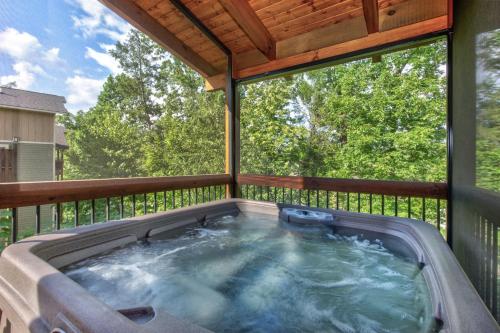 a hot tub on a screened in deck with a view at Running Bear chalet in Gatlinburg