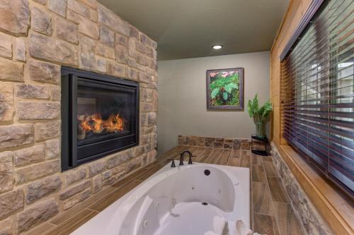 a bath tub in a bathroom with a fireplace at Running Bear chalet in Gatlinburg
