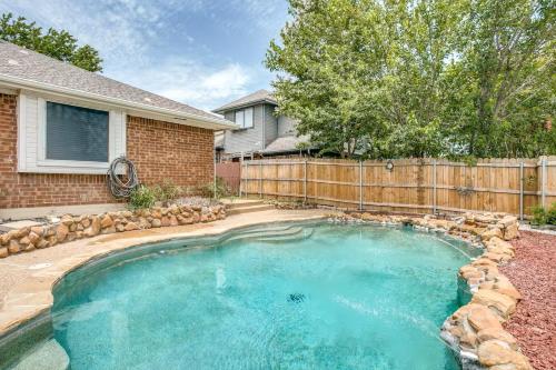 a swimming pool in front of a house with a fence at Family-Friendly Fun, Pool, Game Room, DFW Airport in Lewisville