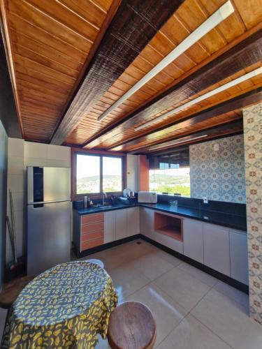 a kitchen with wooden ceilings and a table in it at Pousada Morada dos Pássaros in Pedro Leopoldo