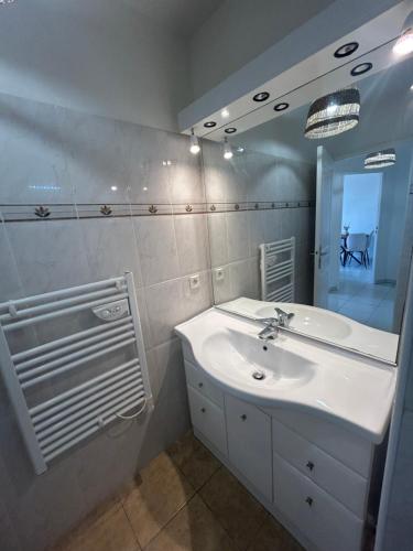 une salle de bain avec un lavabo blanc et un miroir dans l'établissement Appartement frejus, à Fréjus