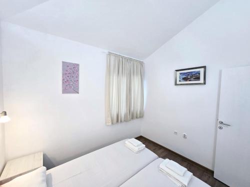 a white room with a bed and a window at Olive trees in Budva