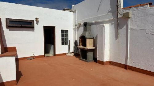 a white building with a fireplace on the side of it at Casa Arena y Mar in Telde