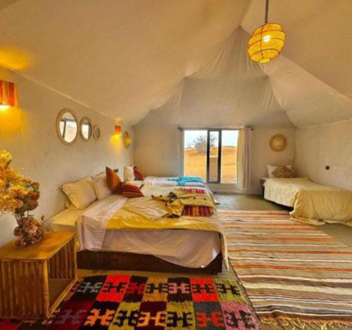 a bedroom with two beds in a tent at lion Desert luxury Camp in Merzouga
