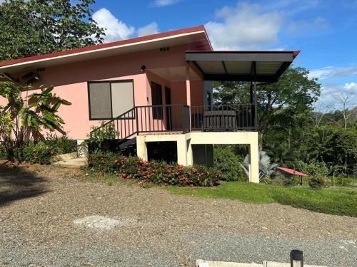 a pink house with a balcony and flowers at Villas Carari in Hatillo