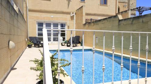 a balcony with a swimming pool in a building at Villa Ambrose Village in San Lawrenz
