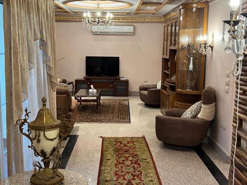 un salon avec des canapés et une télévision à écran plat dans l'établissement فيلا للايجار مفروش بمدينتي, à Madinaty