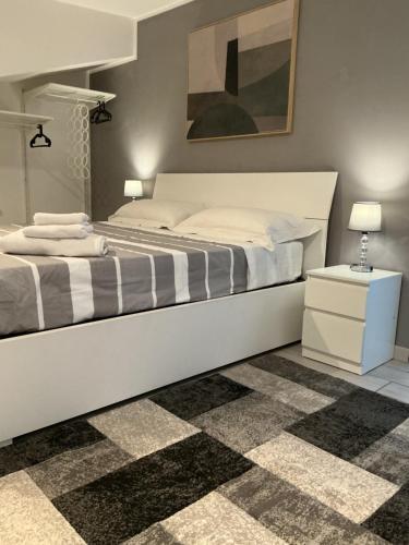 a bedroom with a large white bed and a rug at La Casina sul Tetto in Albano Laziale