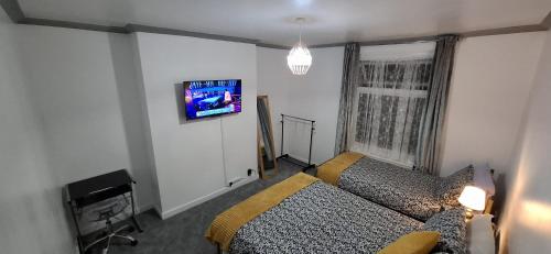 a bedroom with a bed and a tv on a wall at Plymouth Airbnb in Plymouth