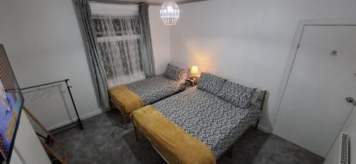 a small bedroom with two beds and a window at Plymouth Airbnb in Plymouth