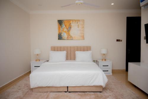 a bedroom with a white bed and two night stands at Premier Hotel Zanzibar Airport in Zanzibar City