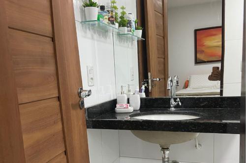 un bagno con lavandino e specchio di Lençóis Park Residence Flat 106 Caburé a Barreirinhas
