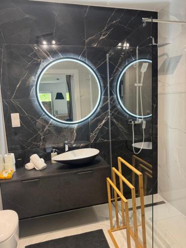 a bathroom with a sink and a mirror at Apartamenty Cegielnia 1 Lux-Haus in Gorzów Wielkopolski
