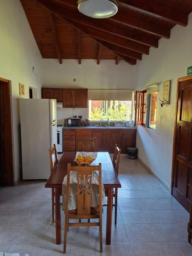 a kitchen with a table and chairs and a refrigerator at Las Casuarinas in San José