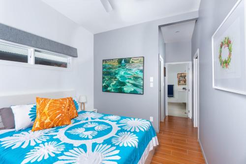 a bedroom with a bed with a blue and white comforter at Panama Beachfront Apartments, Rarotonga in Rarotonga