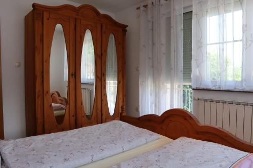 a bedroom with a wooden bed and a mirror at Apartments-Asquiro in Raskršće