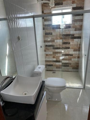 a bathroom with a white toilet and a sink at Minha casa, sua casa in Porto Seguro