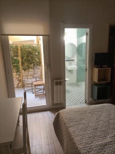 a bedroom with a bed and a sliding glass door at Hostal Quiper in Quiroga