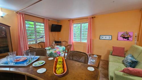 a child sitting at a table in a living room at Pieds dans l'eau F2 pointe du bout trois-Ilets in Lazaret