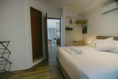 a bedroom with a large white bed and a balcony at HotelZone L20 Beach Access in Cancún