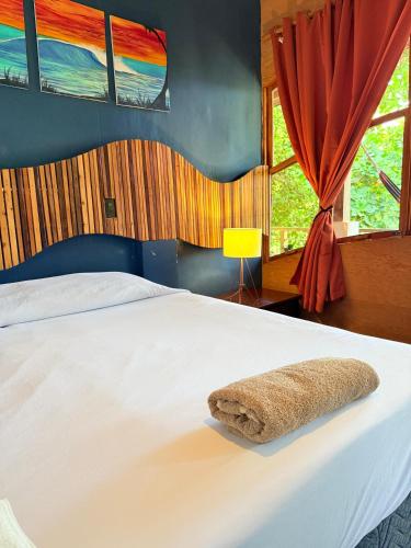 a bedroom with a white bed with a towel on it at Esencia Nativa in El Zonte