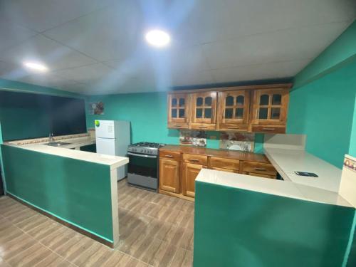 cocina con paredes azules y armarios de madera en Casa Apaneca, en Apaneca