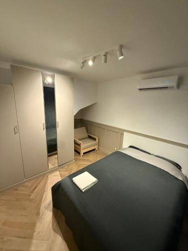 a bedroom with a black bed in a room at Apartamenty Oakland in Debina