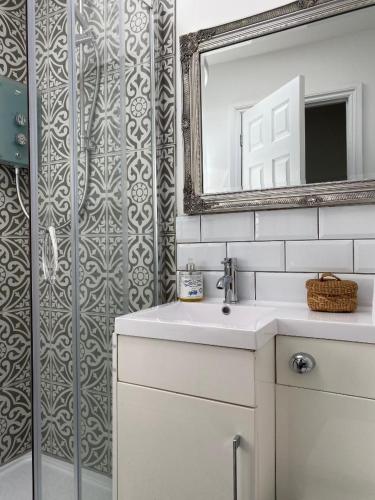 a bathroom with a sink and a mirror and a shower at THE LOFT at 5 St Mary's Street Monmouth in Monmouth