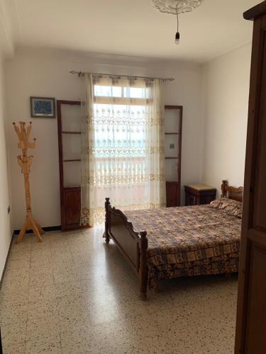 a bedroom with a bed and a window at Chez NAIM in Tichi