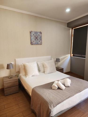 a bedroom with a bed with two towels on it at D'OURO DOM MANUEL By LW in Vila Nova de Gaia
