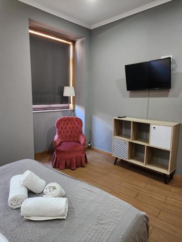 a bedroom with a bed and a chair and a television at D'OURO DOM MANUEL By LW in Vila Nova de Gaia