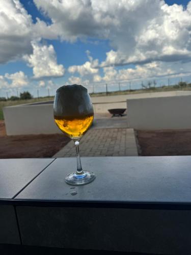 a glass of wine sitting on a table at Kwagae farm in Kuruman